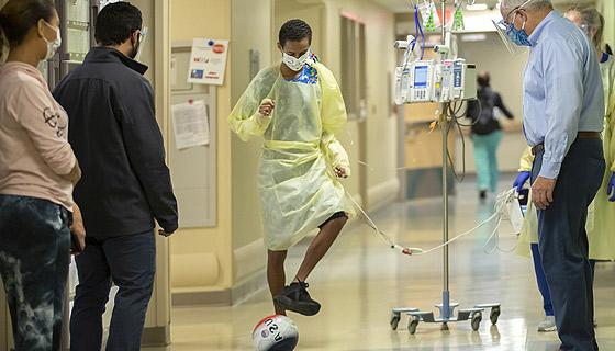 A few days after surgery, 在约翰霍普金斯儿童医院，威尔弗雷和他的护理团队正在走廊里传球.